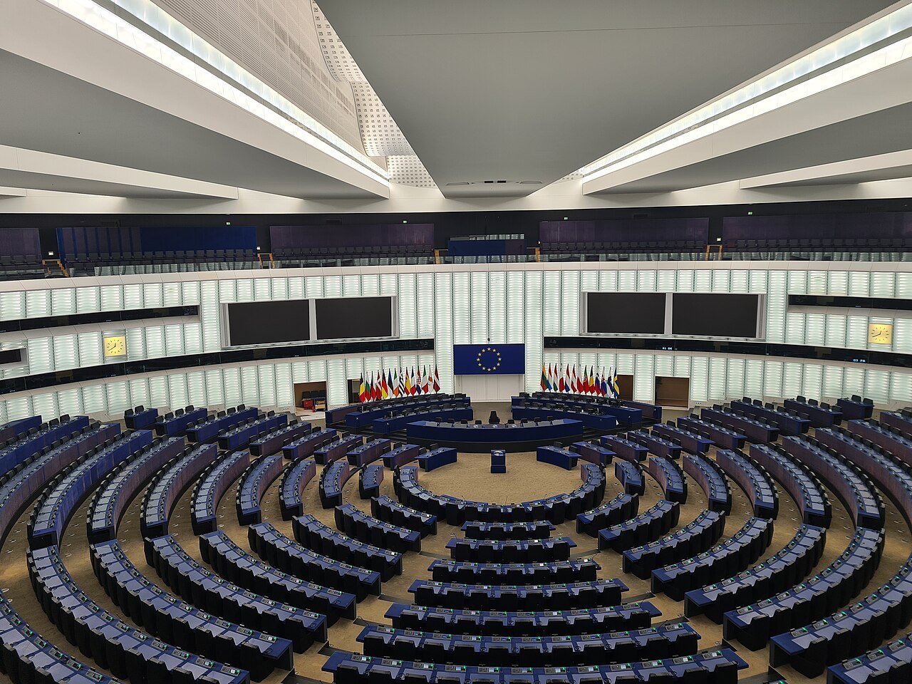 Hemiciclo vacío del Parlamento Europeo en Estrasburgo, con los escaños y las banderas de los Estados miembros.