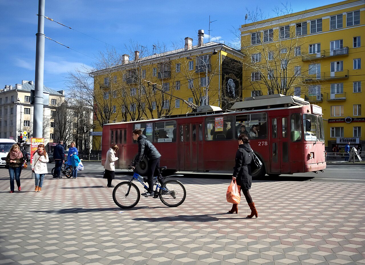 Calle de Petrozavodsk con peatones, un ciclista y un trolebús rojo, en una fotografía de 2014.