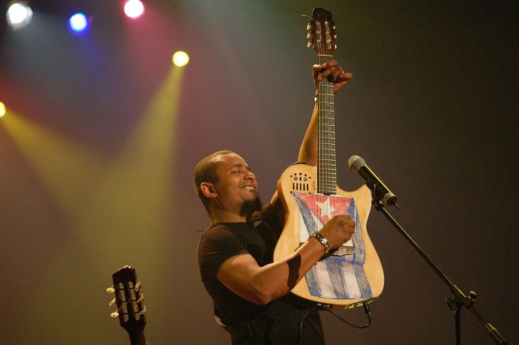 Polito Ibáñez levanta una guitarra con la bandera cubana durante un concierto en 2007.